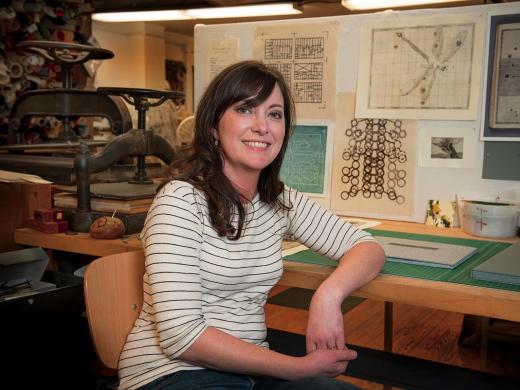 Hulsey in her studio, with letterpress machines behind her