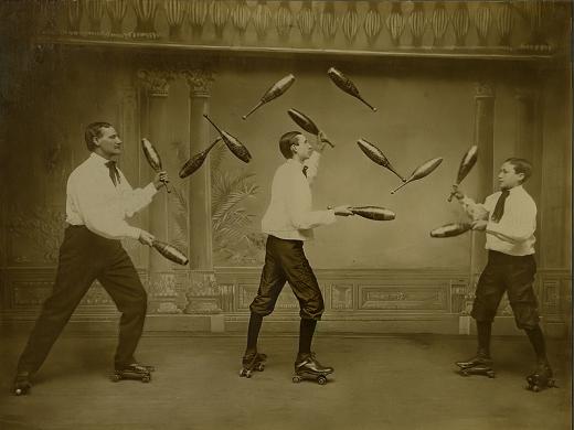 Three men juggle while roller-skating