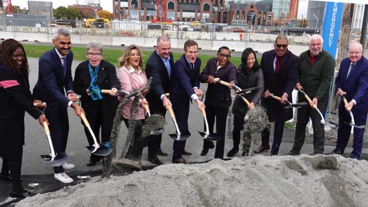 Photograph of stakeholders tossing the first ceremonial shovel of dirt at the groundbreaking on the ERC site in Allston