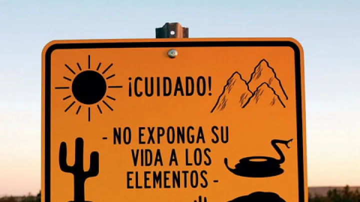 Near Winterhaven, California, an official sign faces south to warn illegal immigrants of dangers in the desert trek&mdash;heat, rugged terrain, rattlesnakes, lack of drinking water, a chance of drowning in a nearby canal&mdash;adding that it is not worth the risk.
