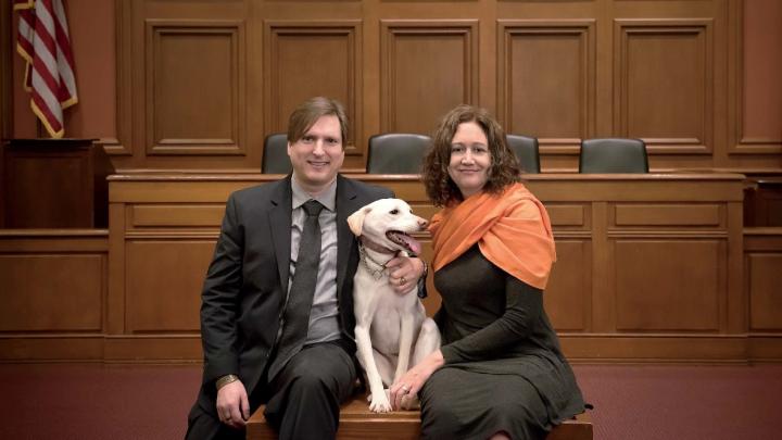 Chris Green and Kristen Stilt in Austin Hall’s Ames courtroom with Lola, Stilt’s rescue dog from Egypt