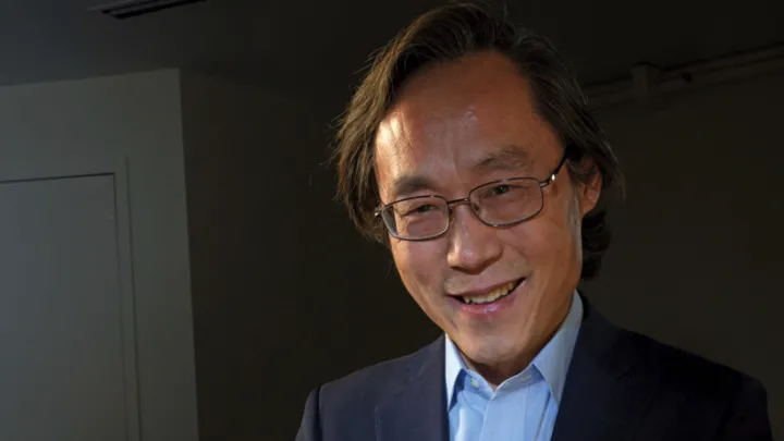 Frank Hu holds a plate filled with food. 