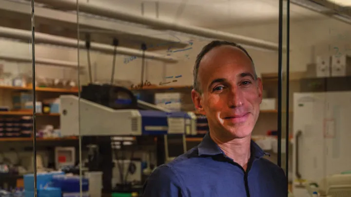 David Reich standing in his Harvard Medical School laboratory