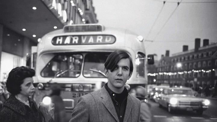 Gram Parsons stands in front of a bus in Harvard Square