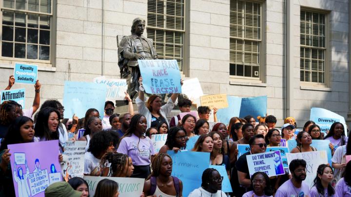 Photograph of student rally against the Supreme Court decision with the John Harvard statue in the background