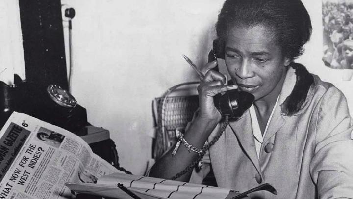 Black journalist Claudia Jones on the phone in the offices of the “West Indian Gazette” in London