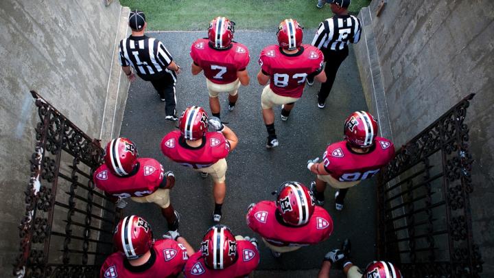 Photo of Harvard football players heading onto the field