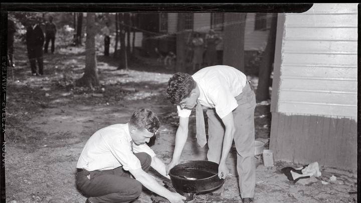 Forensic pioneer Joseph T. Walker (at left) collects blood and scraps of flesh from the bathtub drain of a 1936 murder victim.