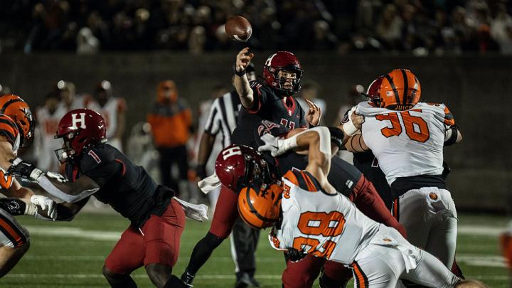 Harvard quarterback Charlie Dean gets off a pass despite Princeton rush.