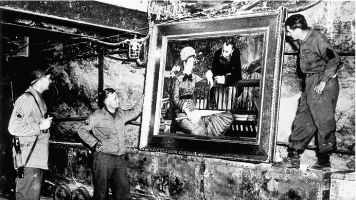 At the Merkers salt mines in central Germany, American GIs admire Édouard Manet’s <em>In the Conservatory,</em> one of the thousands of rare works and documents stored there by the Nazi regime late in World War II. Monuments Man George Stout (see next image), a Fogg Museum conservator turned U.S. Army lieutenant, supervised the rescue of 40 tons of art from the site in April 1945.