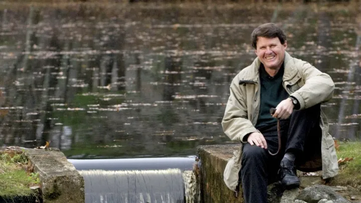 When not dealing with major global water issues, John Briscoe manages this small dam near his home. He holds the hook used to open the sluice gate.