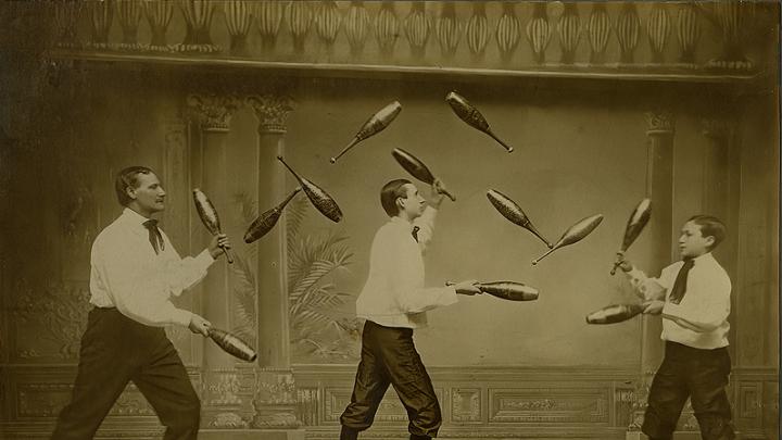 Three men juggle while roller-skating