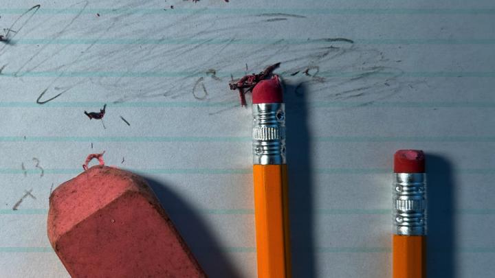 pencils and eraser fragments over an erased piece of paper
