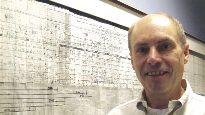 Kunkel with a six-foot-long map showing a portion of the area where the dystrophin gene is located within the human genome. This framed, hand-drawn original was started in 1983 and published in 1986, in the days before high-speed DNA sequencing. 