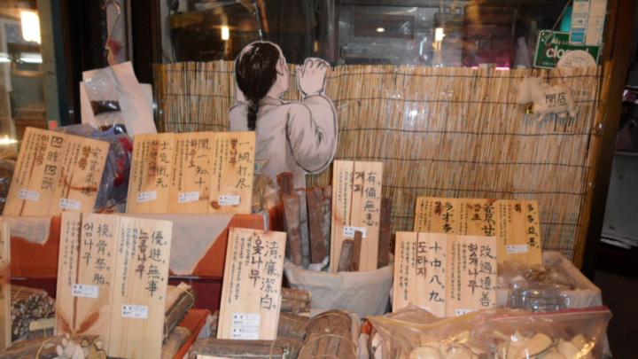 <i>Medicinal Herb Shop at the T’ongin Market</i> - Seoul, Republic of Korea, July 2011. Sun Joo Kim says, “The installation art of the traditionally dressed boy who peers over a fence into the shop was part of the T’ongin Market Project to revitalize traditional markets, designed by local artists who believe that arts must get out of artists’ studios and galleries.”
