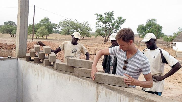 Jordan MacTavish, M.Arch. &rsquo;12, demonstrates how the Sinthian Cultural Center's patterned brickwork will allow for ventilation.