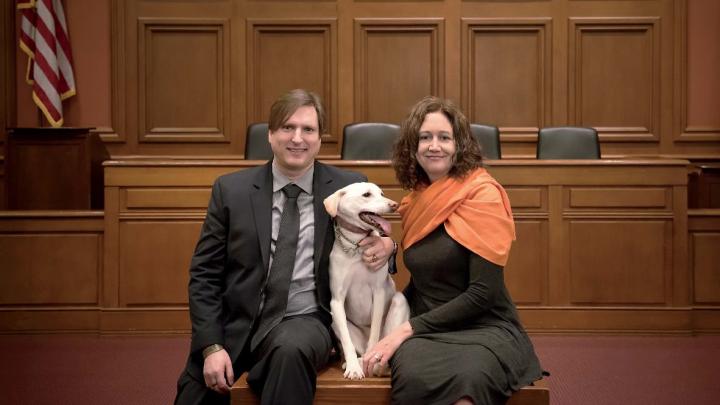 Chris Green and Kristen Stilt in Austin Hall’s Ames courtroom with Lola, Stilt’s rescue dog from Egypt