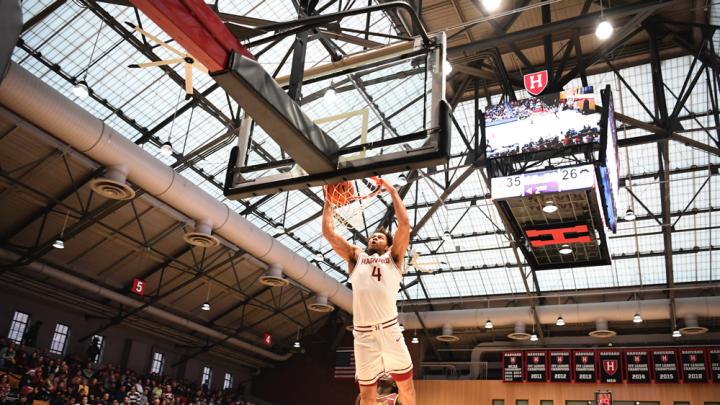 Chris Ledlum dunks the ball in the basket as opposing players trail behind him