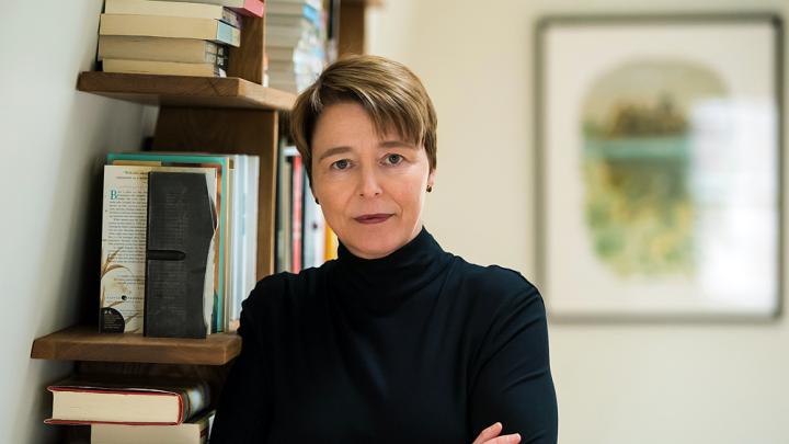 Ophelia Dahl, standing in front of a bookshelf with her arms crossed