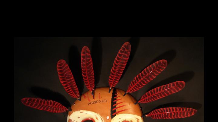 Charette traveled to the Smithsonian Institution in 2003 to view the museum’s Yup’ik holdings; the mask above, from his Poisoned series, shows that trip’s influence and comments on the way museums handled Native American art objects, many of which have sacred value. Charette saw many Yup’ik masks that had been treated with arsenic as a pesticide when the museum acquired them, then further defiled by stamping them with the word “poisoned” once the dangers of topical exposure to arsenic became known.