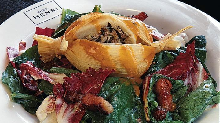 Duck tamale on spinach salad with a warm bacon and mustard dressing from Chez Henri