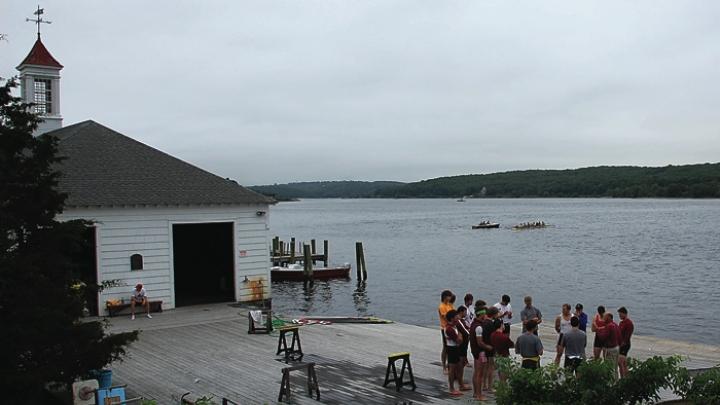Rowers convene with coach Harry Parker. The boathouse, with its eponymous red cupola, is at left.