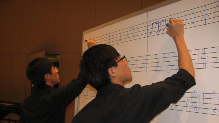 At a rehearsal, twins Seungsoo Kim ’13 and Seungjun Kim ’13 practice a number that involves tapping out sounds with markers on a whiteboard. 