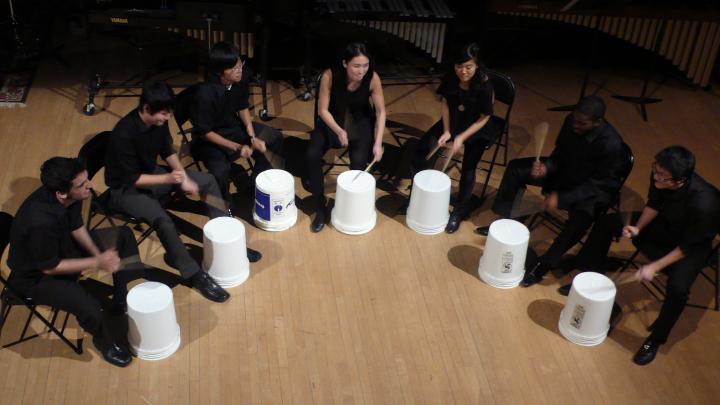 The ensemble's trademark is using offbeat objects, such as stools and buckets, as well as traditional percussion instruments.