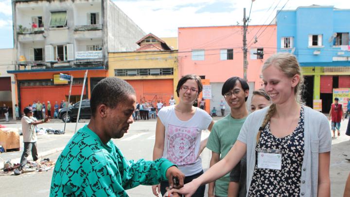 During a tour of a shantytown in the heart of São Paulo, a resident feigns a wedding proposal to HSPH’s Sarah MacDonald, as University of São Paulo's Ana Carolina Navarrete (left) and HSPH's Panji Hadisoemarto look on.