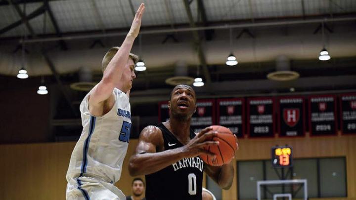 Chris Lewis, ball in hand, drives past opponent