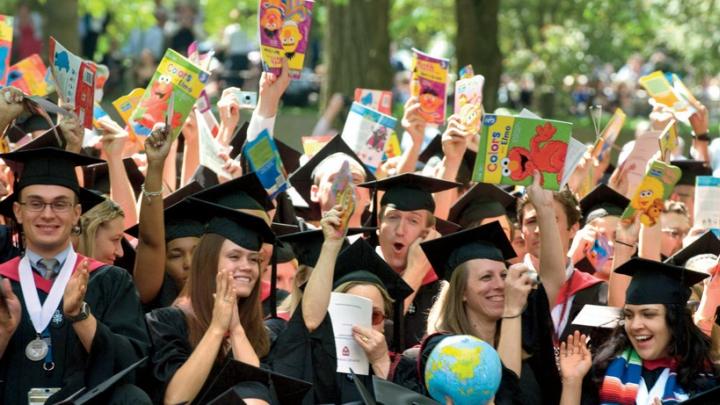 Still bullish on books: School of Education graduates celebrate their degrees. The picture books they carry are donated later; this year, half the books went to the Make-A-Wish Foundation, and half to the Reach Out and Read program at Children's Hospital Boston.