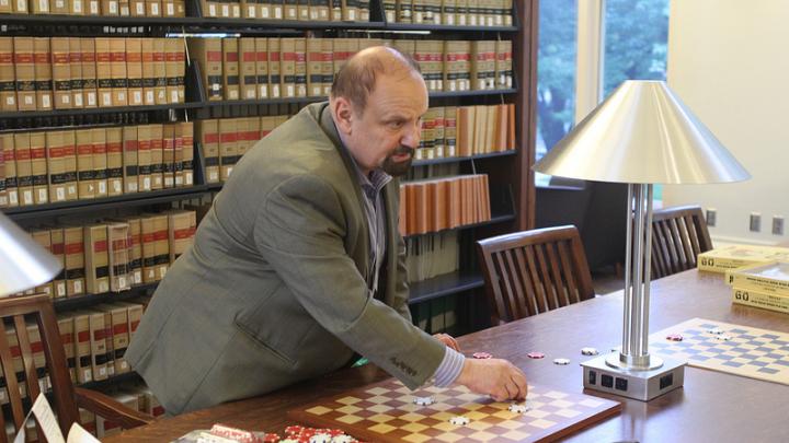International draughts master Alex Mogilyansky with board and checkers in Langdell Library