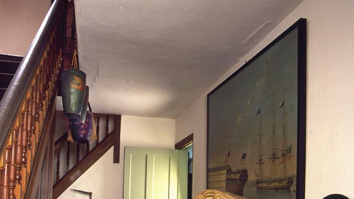 In the hallway, an 1814 oil painting depicts the launching of the U.S. frigate <i>Washington</i> at the Portsmouth, New Hampshire, Navy Yard. In the rear stands an ingenious 1907 carved crane decoy that folds up to fit into a hunter&rsquo;s pack. 