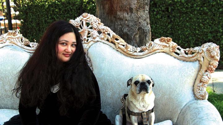 Author Gabrielle Zevin seated on a sofa in Los Angeles with her dog Nico