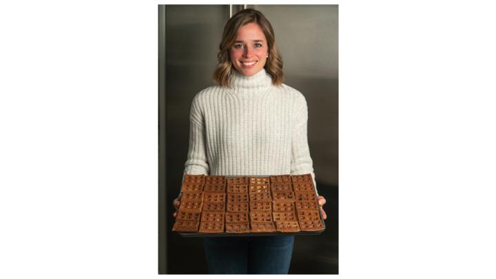 A woman holds a tray of waffles