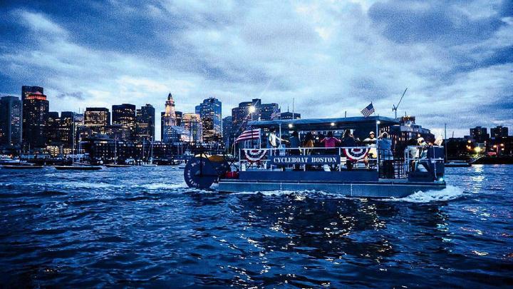 Boat cruising on Boston harbor at twilight 
