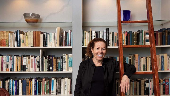 Wendy Lesser standing happily among her books 