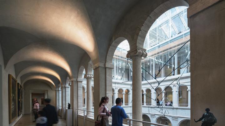A few visitors in the arcade overlooking the Calderwood Courtyard of the Harvard Art Museums