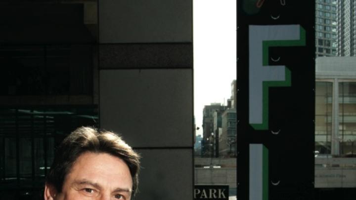 Richard Peña at Lincoln Center, with a New York Film Festival banner at right, behind him