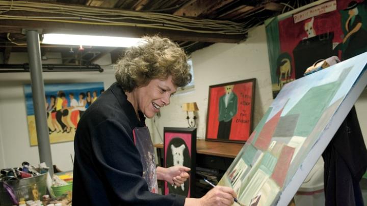 Surrounded by her own works, Langer wields a brush in her home studio.  A self-taught painter who took up the avocation in midlife, she describes her autodidactic approach to art in <em>On Becoming an Artist: Reinventing Yourself Through Mindful Creativity</em> (2005).