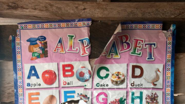 A torn alphabet poster hangs in the nursery of Desmercy School, where the students come from relatively low-income families. Though the school has benefited thanks to microfinance loans from Opportunity International, parents such as Richard Dedzoe, a mason, and Florence Oppong, a trader in foodstuffs, hope Opportunity International will further assist the school in improving its  computer training and plumbing.