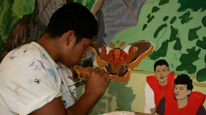 Student painting a section of <i>Mystic River Mural</i>