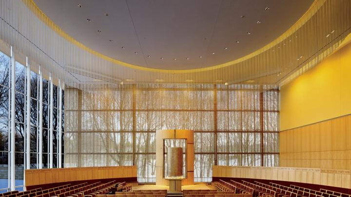 The interior of Temple Beth Elohim in Wellesley, Massachusetts, looking onto a wooded landscape