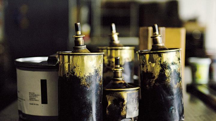 A can of black ink (on the left) and brass cans of type wash 