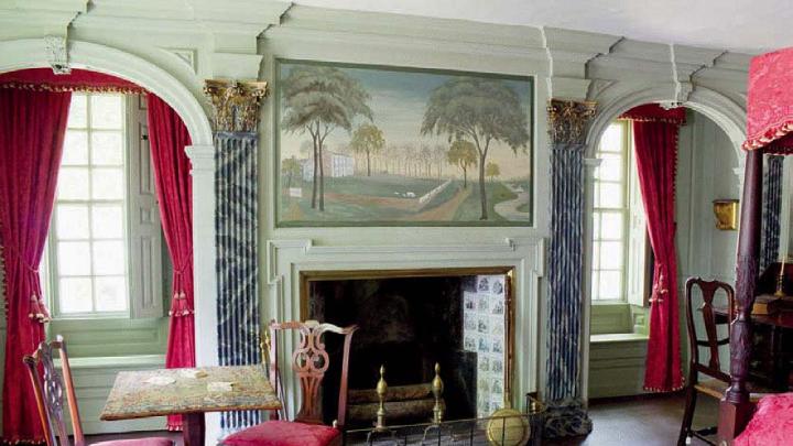 A grand bedroom with four-poster bed and elegant fireplace in the main house.