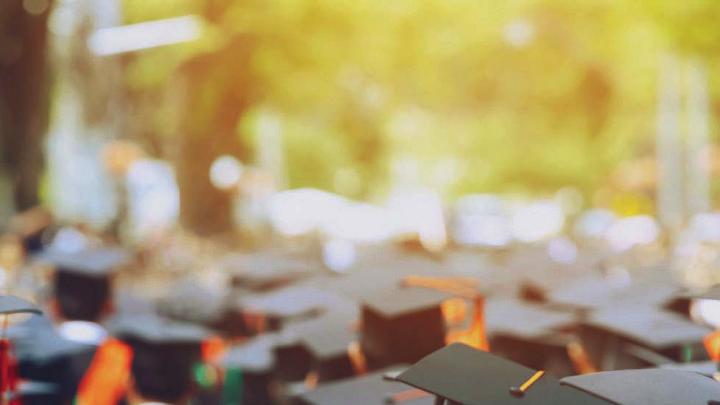 Photograph of students in caps and gowns graduating from college