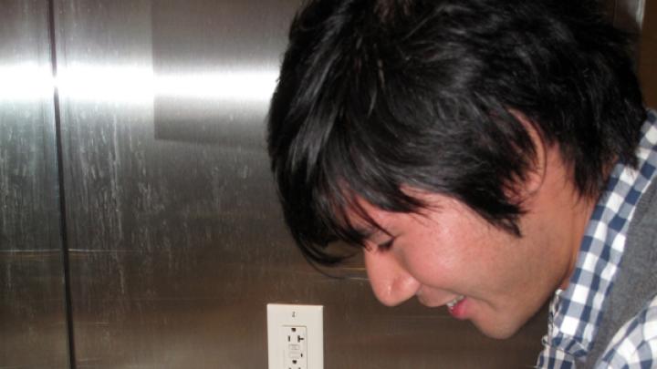 A student using a "Tapminder" device in the men's bathroom