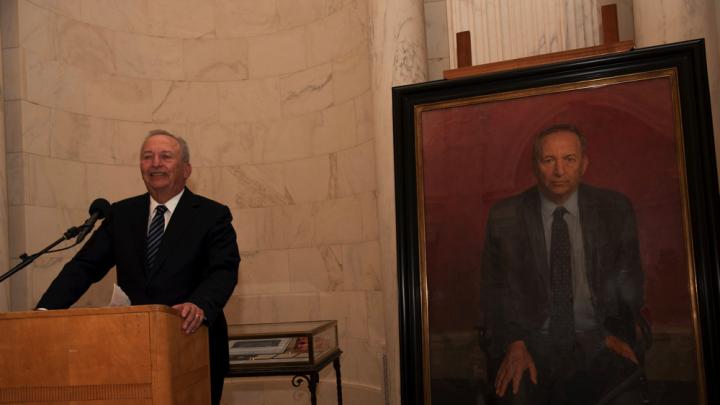 Lawrence H. Summers at the lectern next to his official portrait