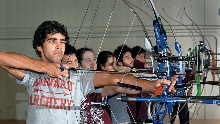 Samuel Saidel-Goley (foreground) and Archery Club colleagues draw their bows.