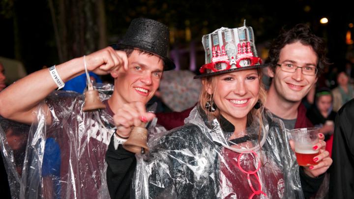 Students from the Harvard Business School (HBS) party on despite the rain. The HBS contingent in the parade carried replicas of the centennial bell from that school's 2008 anniversary.
